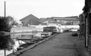 Punts outside old Packet Boat Stables (now the Water Witch Pub) looking North, with old buildings across the canal in the background