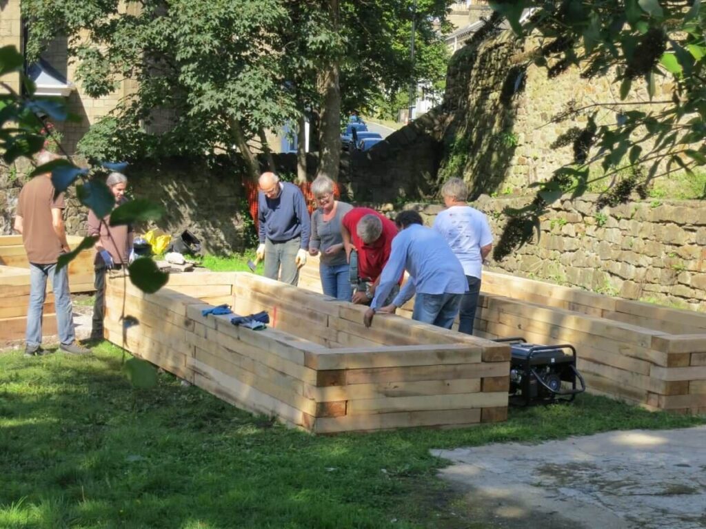 People around one of the beds as the blocks are nailed in place