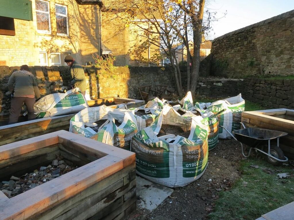 Bags of earth beside the raised beds