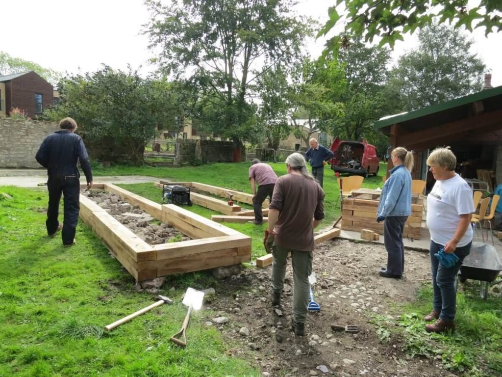 People standing around one of the half constructed beds