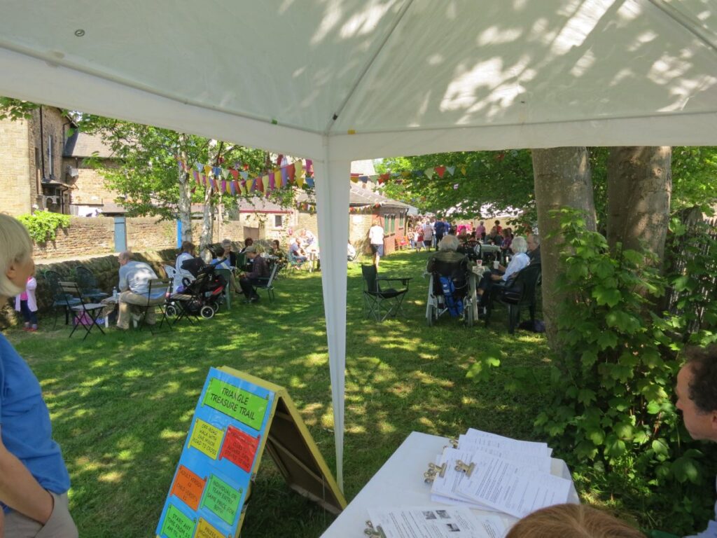 People attending the stalls, treasure trail and BBQ at the Triangle in the sunshine