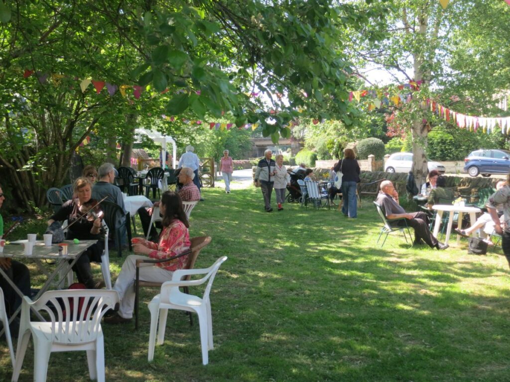 People attending the stalls, treasure trail and BBQ at the Triangle in the sunshine