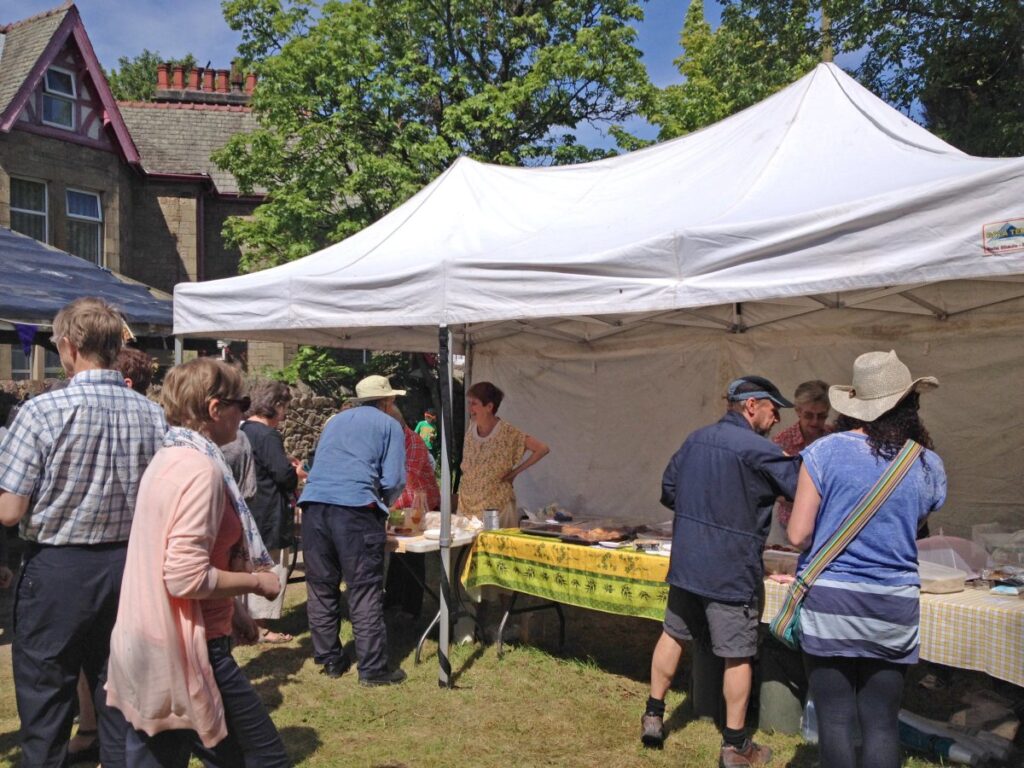 People attending the stalls, treasure trail and BBQ at the Triangle in the sunshine