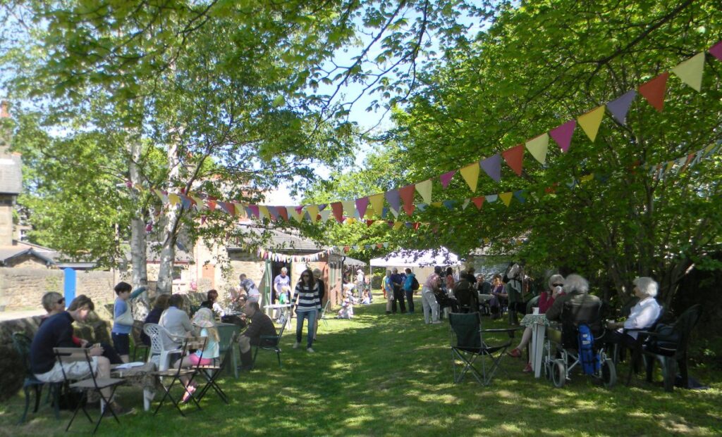 People attending the stalls, treasure trail and BBQ at the Triangle in the sunshine