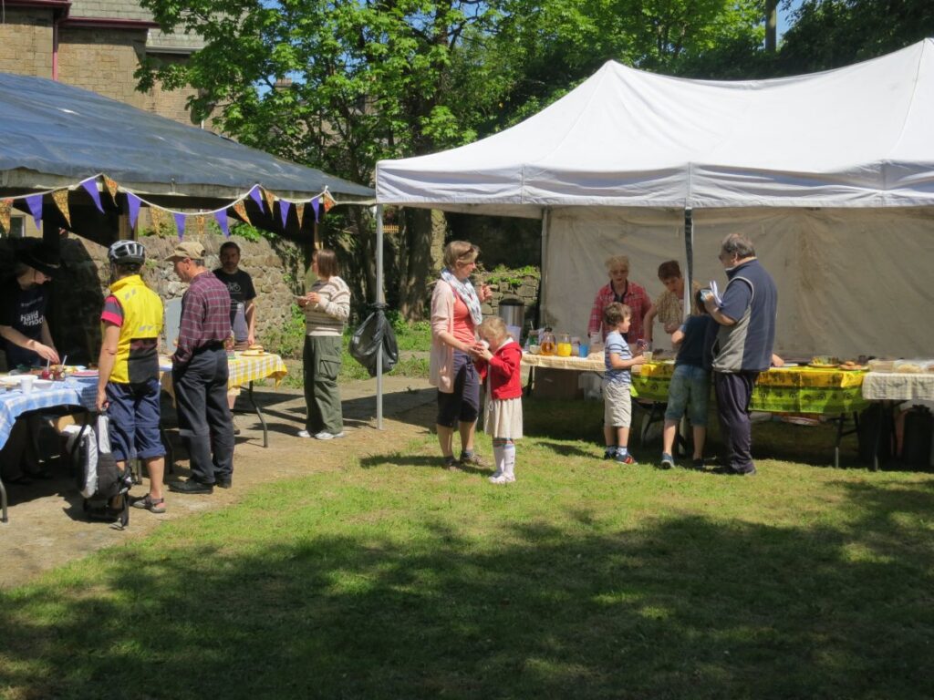 People attending the stalls, treasure trail and BBQ at the Triangle in the sunshine