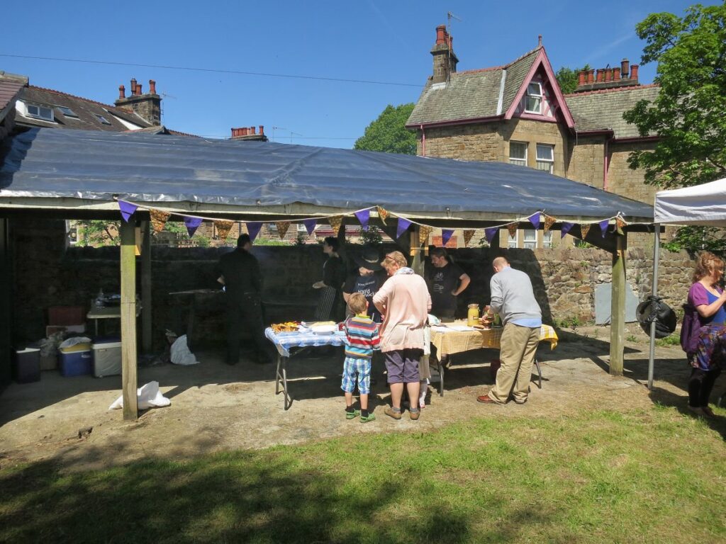 People attending the stalls, treasure trail and BBQ at the Triangle in the sunshine