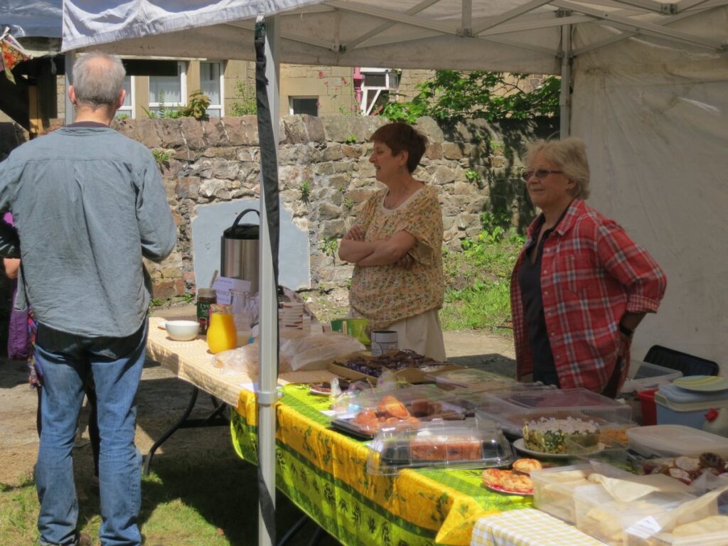 People attending the stalls, treasure trail and BBQ at the Triangle in the sunshine