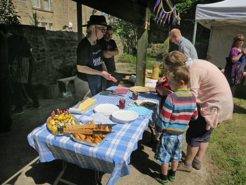 People attending the stalls, treasure trail and BBQ at the Triangle in the sunshine