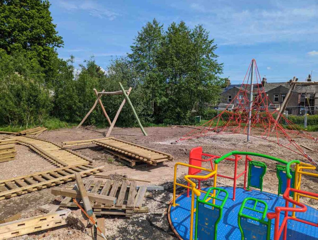 wide shot of the playground under construction with fences on the ground and bare earth